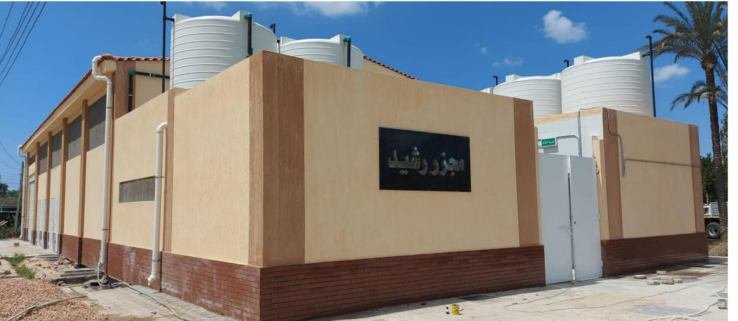 Completed industrial facility building with water storage tanks